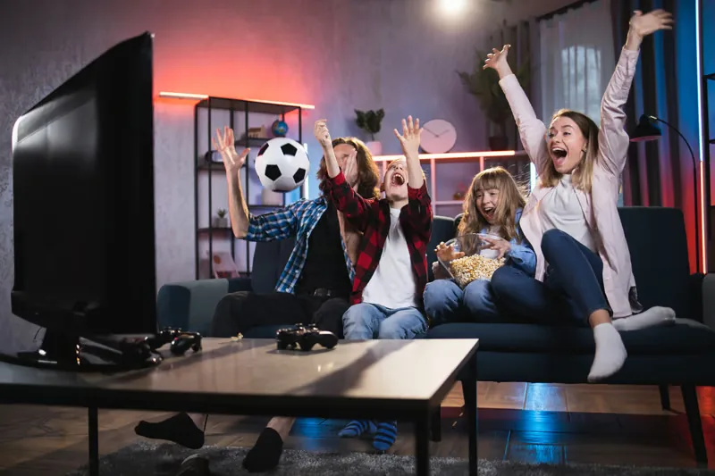 Family celebrating while watching live sport on IPTV at home