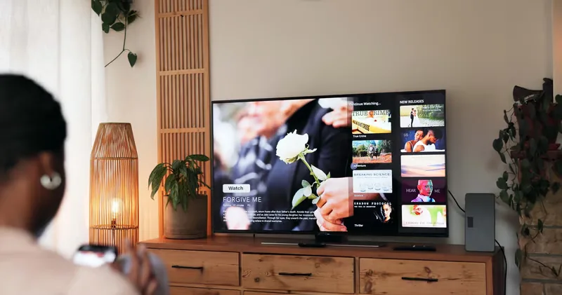 Person browsing IPTV USA channels and on-demand titles on a Smart TV