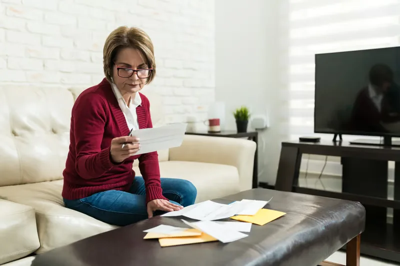 Person reviewing monthly cable bills to see how much cable costs