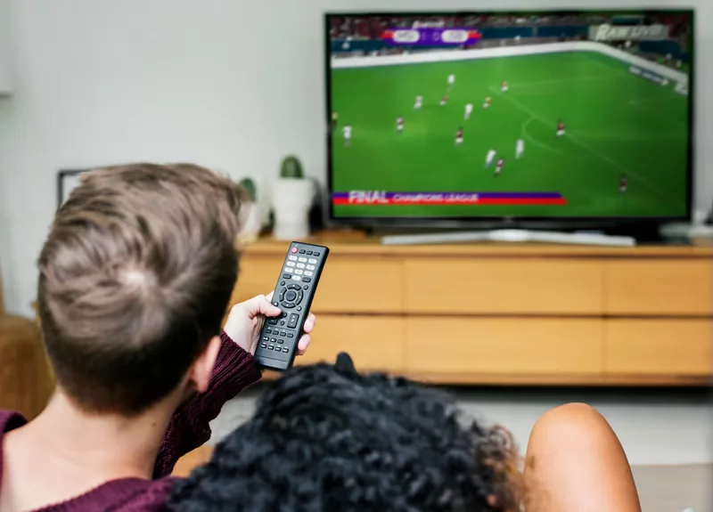 Couple watching live football on IPTV without cable in their living room