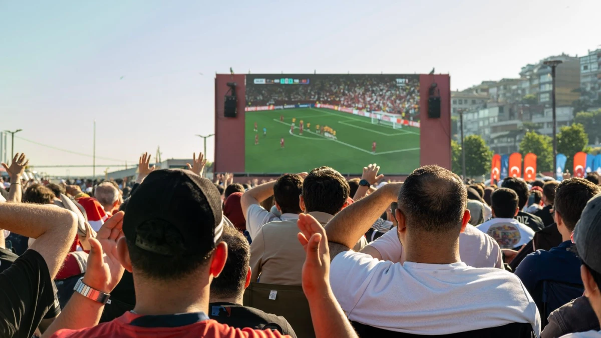 Fans watching a live football match on a big screen during peak hours